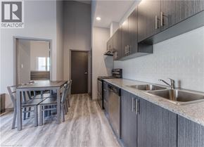 Waterloo condo for rent - A modern kitchen with dark wood cabinets and a stainless steel dishwasher.