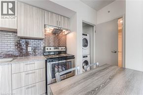 Waterloo condo for rent - A modern kitchen with a stove top oven and a washing machine built into the cabinetry.