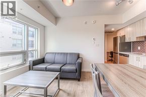 Waterloo condo for rent - A modern living room with a grey sofa and a wooden dining table.