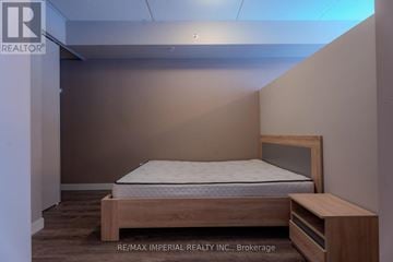 Waterloo condo for rent - A bedroom with a bed and a nightstand.