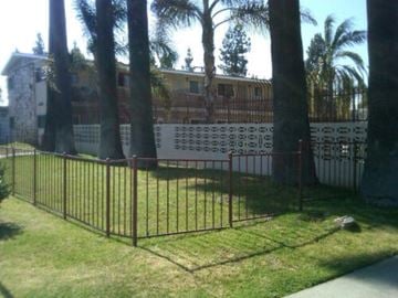 Montclair apartment for rent - A black metal fence with a gate is in front of a house.