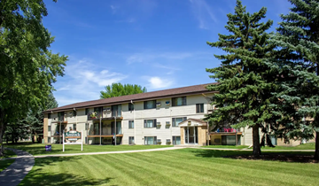 Fargo apartment for rent - A building with a sign that says "Apartments" in front of it.