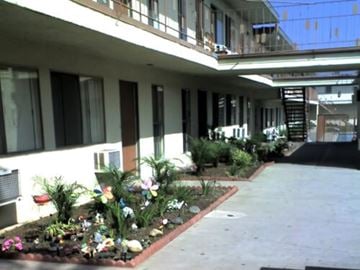 Azusa apartment for rent - A building with a balcony and a flower bed in front.