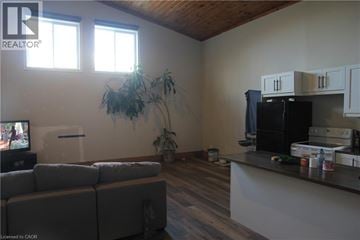 Cayuga house for rent - A living room with a grey couch and a wooden ceiling.