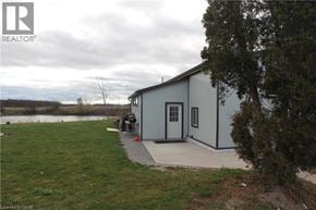 Cayuga house for rent - A small house with a grey roof and a white door is situated in a grassy area.