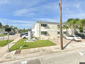 Tampa apartment for rent - A street view of a residential area with a house, cars, and a traffic light.