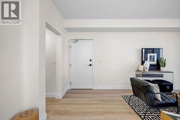 Tecumseh apartment for rent - A living room with a black couch and a white door.