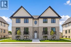 Tecumseh apartment for rent - A two-story house with a white front door and black railings on the balconies.