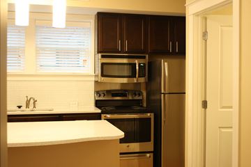 St. Louis apartment for rent - A kitchen with a white counter top and stainless steel appliances.