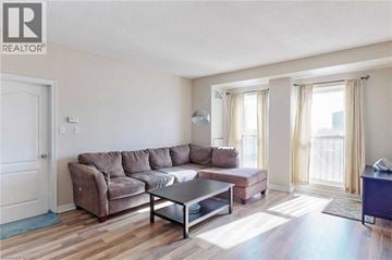 Hamilton condo for rent - A living room with a brown couch and a glass coffee table.