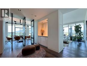 Vancouver apartment for rent - A modern living room with a large window and a dining area.