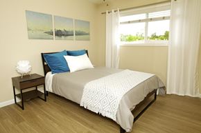 San Jose apartment for rent - a bedroom with a bed with white sheets and blue pillows