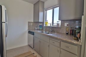 Belmont apartment for rent - a kitchen with white cabinets and a sink and a window