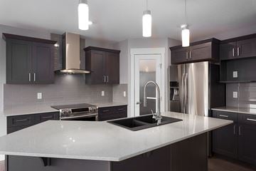Spruce Grove apartment for rent - A modern kitchen with dark brown cabinets and a white countertop.