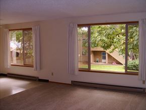 Gresham apartment for rent - an empty living room with large windows looking out to a yard