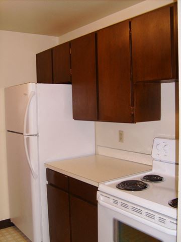 Gresham apartment for rent - a kitchen with white appliances and brown cabinets and a refrigerator