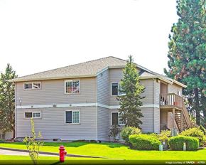 Bend apartment for rent - a white house with a red fire hydrant in the grass
