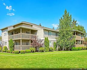 Bend apartment for rent - an apartment building with a green lawn and trees