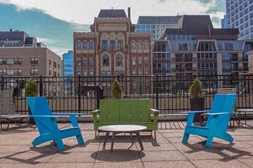 Chicago apartment for rent - A green bench is in the middle of three blue chairs.