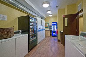 Chicago apartment for rent - A laundry room with a washer and dryer, a basket, and a vending machine.