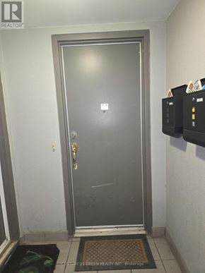 Toronto (York University Heights) townhouse for rent - A grey door with a handle and a keyhole is in a room.