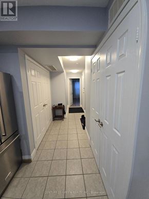 Toronto (York University Heights) townhouse for rent - A hallway with white doors and a tiled floor.