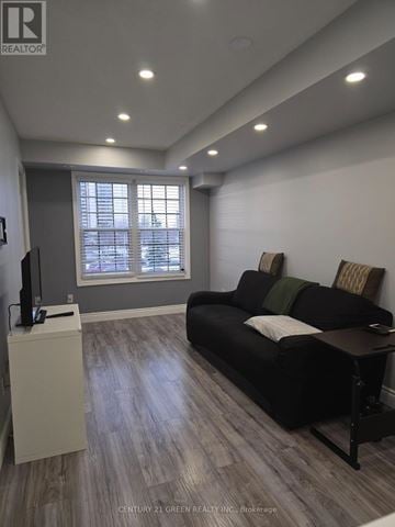 Toronto (York University Heights) townhouse for rent - A living room with a black couch and a television.