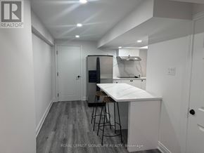 For rent in Markham (Village Green-South Unionville) - A white kitchen with a table and chairs in a room with white walls.