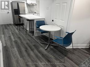 For rent in Markham (Village Green-South Unionville) - A dining area with a white table and blue chairs.
