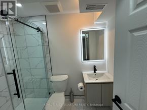 For rent in Markham (Village Green-South Unionville) - A white toilet with a glass shower door in a bathroom.