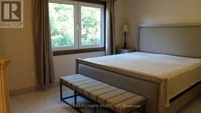 Mississauga (Sheridan) house for rent - A bedroom with a bed, bench, and window.