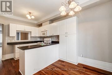 Ottawa condo for rent - A kitchen with white cabinets and a black countertop.