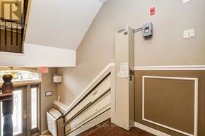 Ottawa condo for rent - A hallway with a staircase and a wall-mounted elevator control panel.