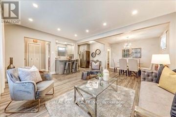 Toronto (Wexford-Maryvale) house for rent - A well-lit, spacious living room with a glass coffee table and a blue armchair.