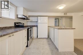Kitchener house for rent - A kitchen with white appliances and cabinets.
