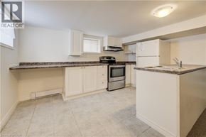 Kitchener house for rent - A kitchen with white cabinets and a granite countertop.