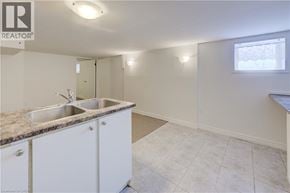 Kitchener house for rent - A kitchen with white cabinets and a granite countertop.
