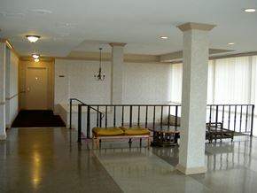 Falls Church apartment for rent - the lobby of a building with a staircase and yellow chairs
