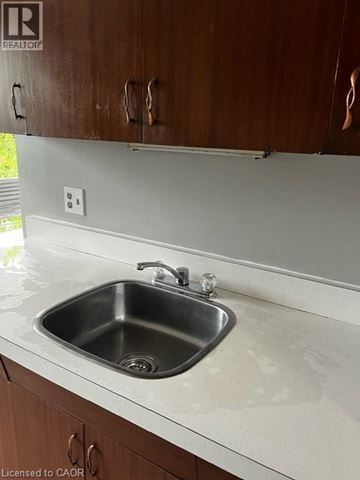 Kitchener condo for rent - A kitchen sink with a faucet and a countertop.