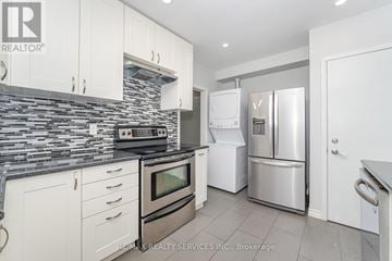 Brampton (Avondale) house for rent - A kitchen with white cabinets and a stone backsplash.