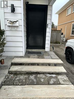 Toronto (Lansing-Westgate) house for rent - A black door is on the left side of a white house.