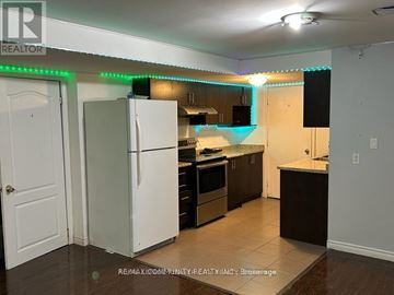Brampton (Fletcher's Meadow) house for rent - A kitchen with a white refrigerator and wooden cabinets.