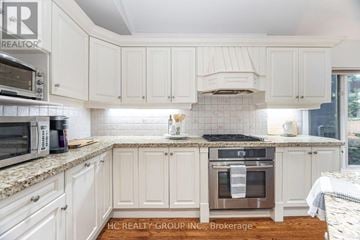 Toronto (Edenbridge-Humber Valley) house for rent - A kitchen with white cabinets and a tile backsplash.