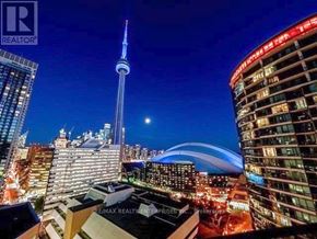 Toronto (Waterfront Communities) condo for rent - A cityscape at night with the CN Tower prominently displayed.