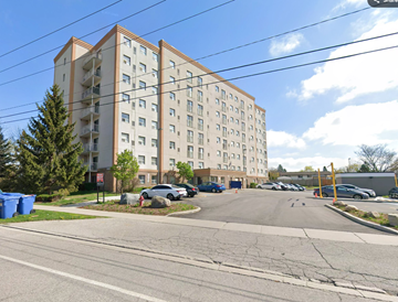 Kitchener apartment for rent - A large apartment building with a parking lot in front.