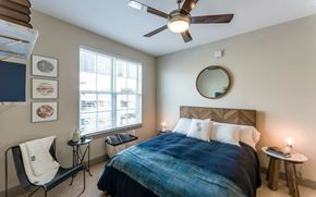 New Orleans apartment for rent - A bedroom with a bed, chair, and a ceiling fan.
