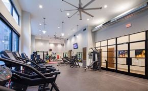 New Orleans apartment for rent - a gym with weights and chairs and a ceiling fan