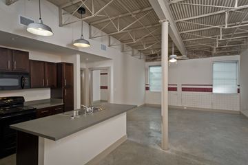 New Orleans apartment for rent - an open kitchen and living room in a building with exposed ceilings