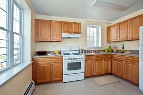 Staten Island apartment for rent - a kitchen with white appliances and wooden cabinets