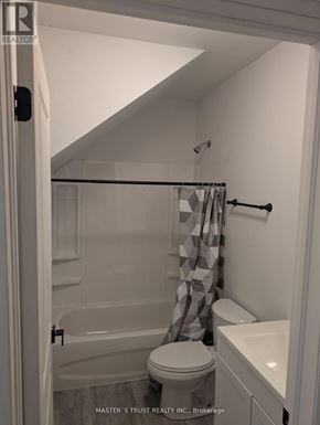Uxbridge condo for rent - A white bathroom with a toilet, sink, and bathtub.